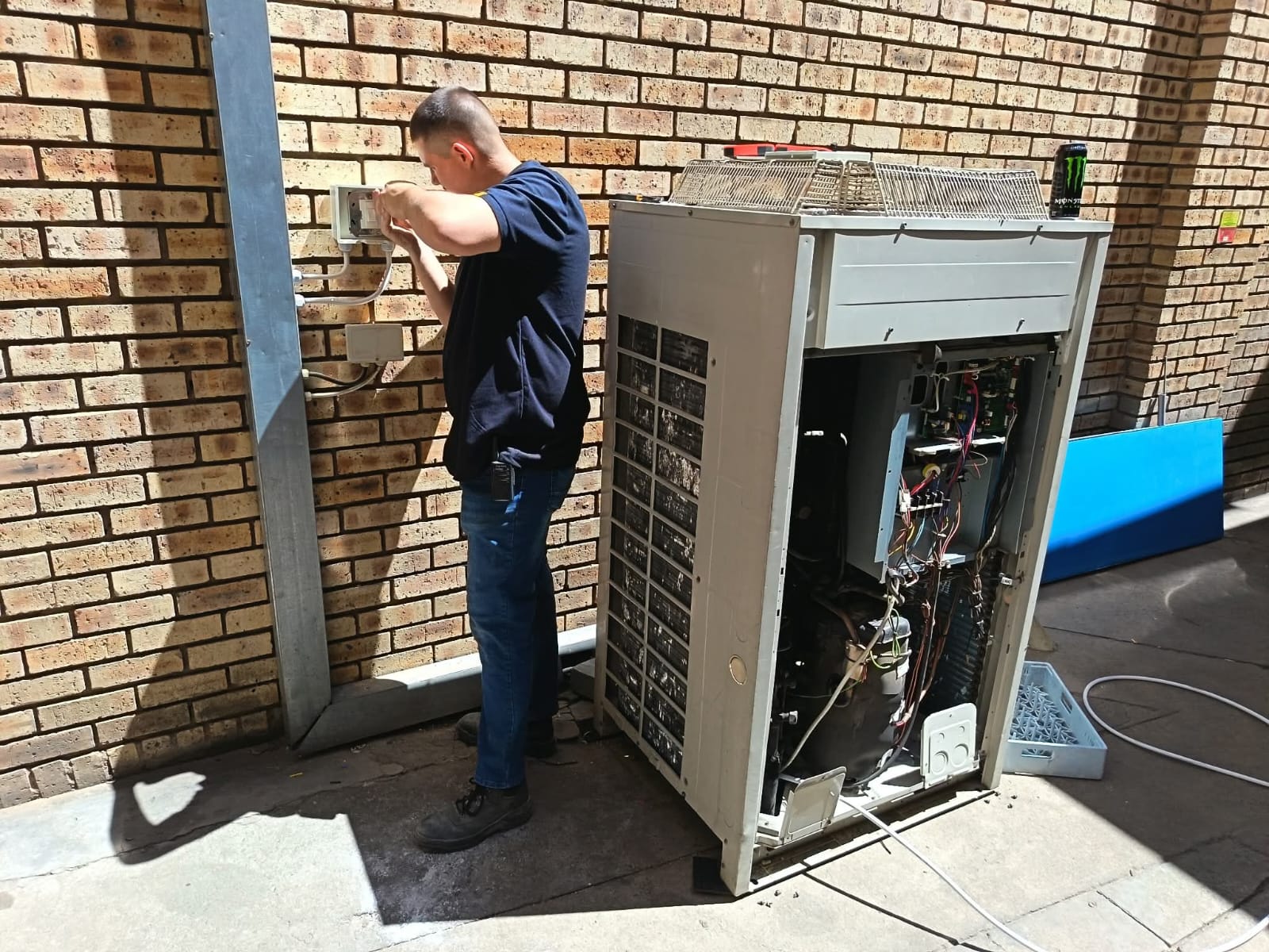 Artic Airconditioning technician repairing outdoor air conditioning unit